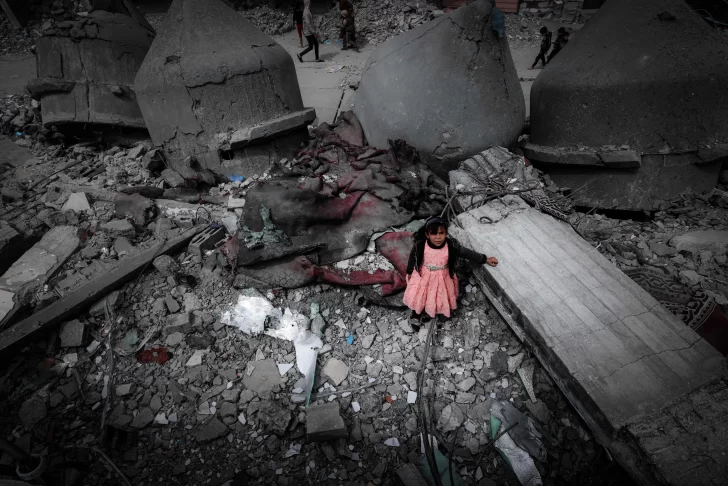 AFP.Una-nina-palestina-con-un-vestido-rosa-se-encuentra-en-medio-de-las-ruinas-de-la-mezquita-Al-Faruq-728x486